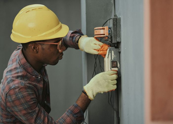 Eletricista trabalhando em quadro elétrico